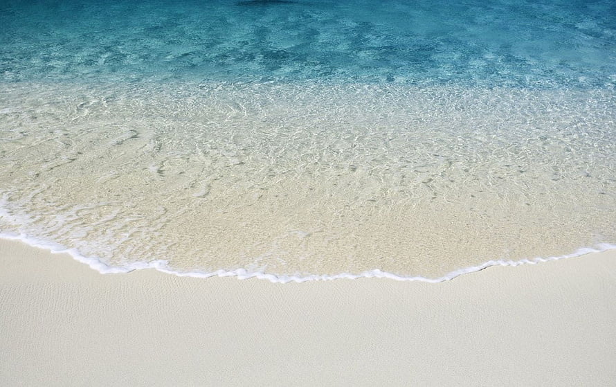 Aerial View of Turquoise Ocean Waves Lapping Against White Sand Beach HD wallpaper