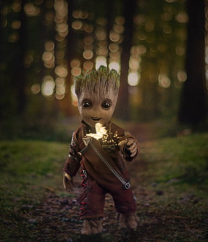 Baby Groot in a forest clearing with a glowing butterfly HD phone wallpaper