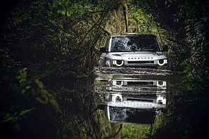 Land Rover Defender Forging Through a Forest Stream With Mirror Reflection HD wallpaper