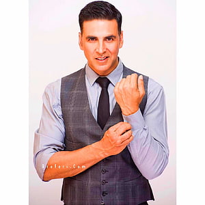 Akshay Kumar in a grey plaid vest and light blue shirt adjusting his cuff HD phone wallpaper