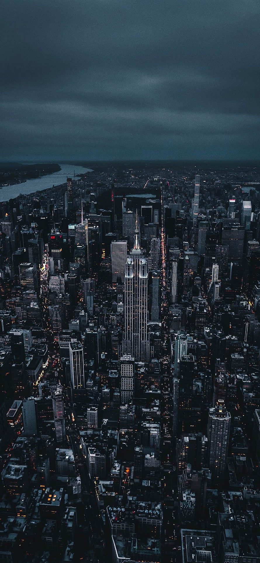 Aerial View of Manhattan Skyline at Night Featuring the Empire State Building Under Stormy Clouds HD phone wallpaper