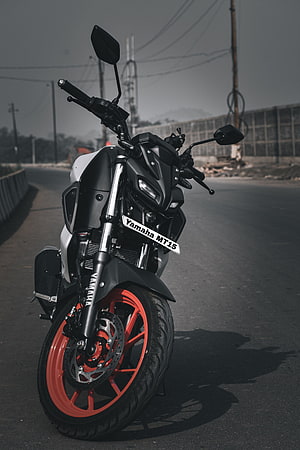 Yamaha MT-15 Motorcycle with Red Rims Parked on an Open Road HD phone wallpaper