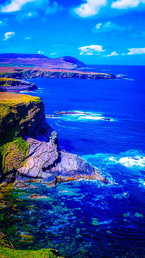 Dramatic Coastal Cliffs and Turquoise Ocean Waters Under a Bright Blue Sky HD phone wallpaper