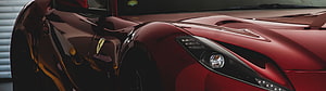 Close-up of a glossy red Ferrari front fender and headlight assembly HD wallpaper