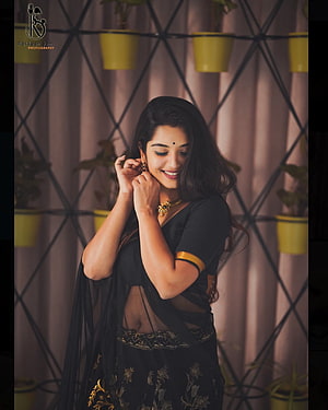 Priyanka M Jain in Black Saree with Gold Jewelry and Floral Background HD phone wallpaper
