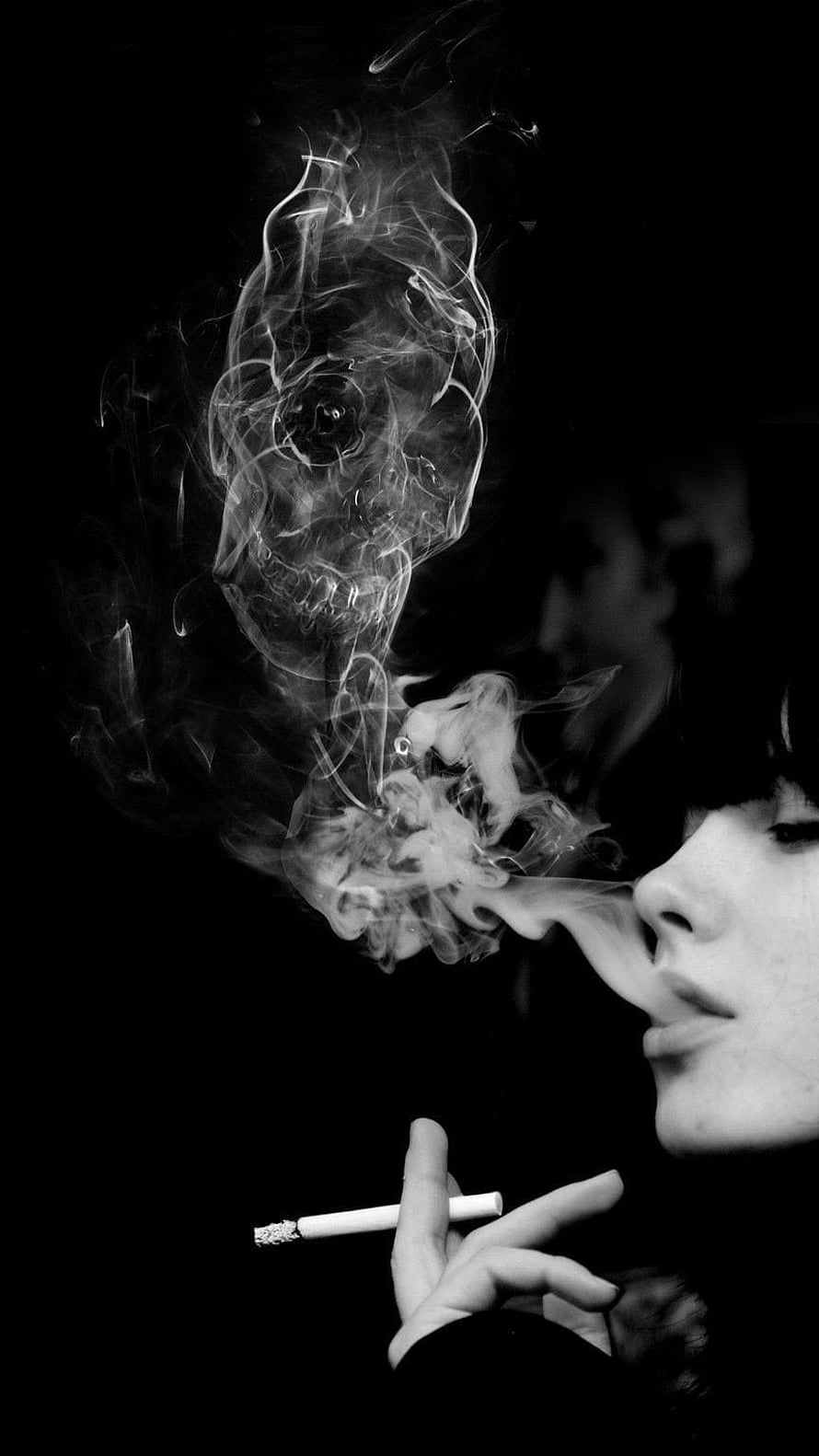 Black and white portrait of a woman exhaling smoke that forms a skull shape against a dark background HD phone wallpaper