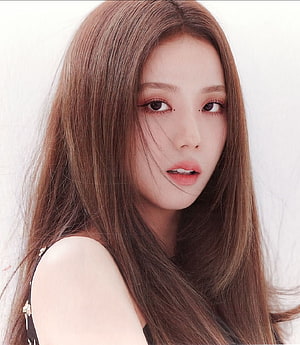 Jisoo from Blackpink in a soft-focus portrait with long brown hair and delicate makeup HD phone wallpaper