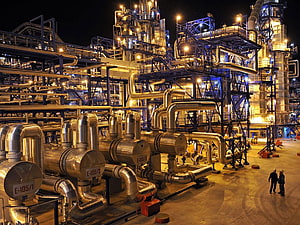 Illuminated Oil Refinery Complex at Night with Industrial Piping and Storage Tanks HD wallpaper