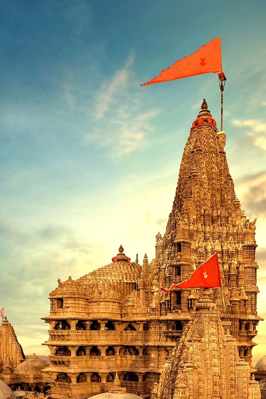 Dwarkadhish Temple in Dwarka, Gujarat, India with red flags against a blue sky HD phone wallpaper