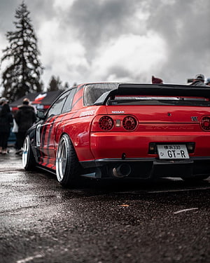 Rear View of a Modified Red Nissan Skyline GT-R R32 with Widebody Kit and Custom Wheels HD phone wallpaper