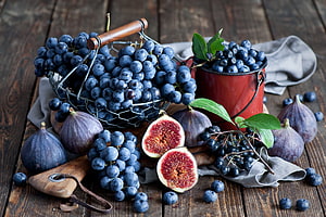 Rustic Still Life of Blue Grapes, Figs, and Bilberries on a Weathered Wooden Table HD wallpaper