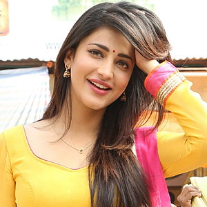 Shruti Haasan in a vibrant yellow and pink traditional outfit with a warm smile HD phone wallpaper
