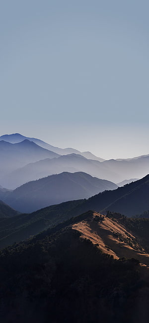Layered Mountain Ranges in Misty Dawn Light with Golden Ridge Foreground HD phone wallpaper