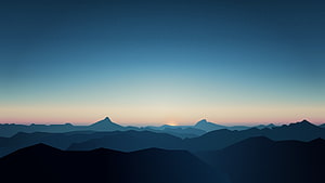 Minimalist Dark Blue Mountain Silhouettes at Dawn with Soft Sunrise Glow HD wallpaper