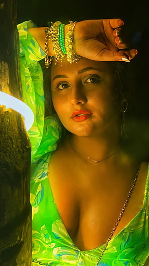 Reshmi Desai in Green Floral Dress with Gold Jewelry and Dramatic Warm Lighting HD phone wallpaper