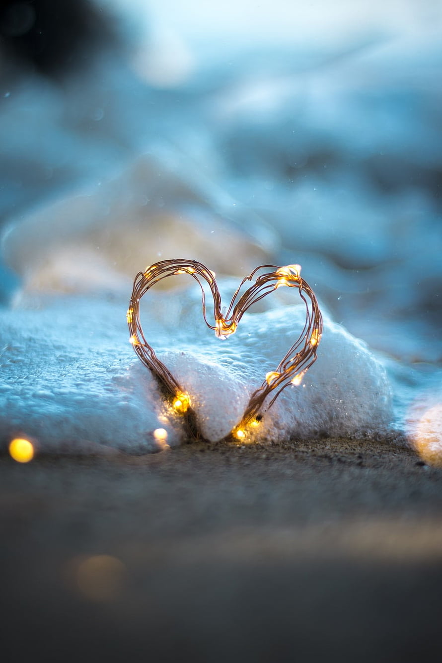 Heart-Shaped Fairy Lights on Snowy Rock in Cool Blue Winter Setting HD phone wallpaper