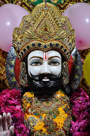 Ornate Hindu Deity Idol with Golden Crown and Floral Garlands HD phone wallpaper