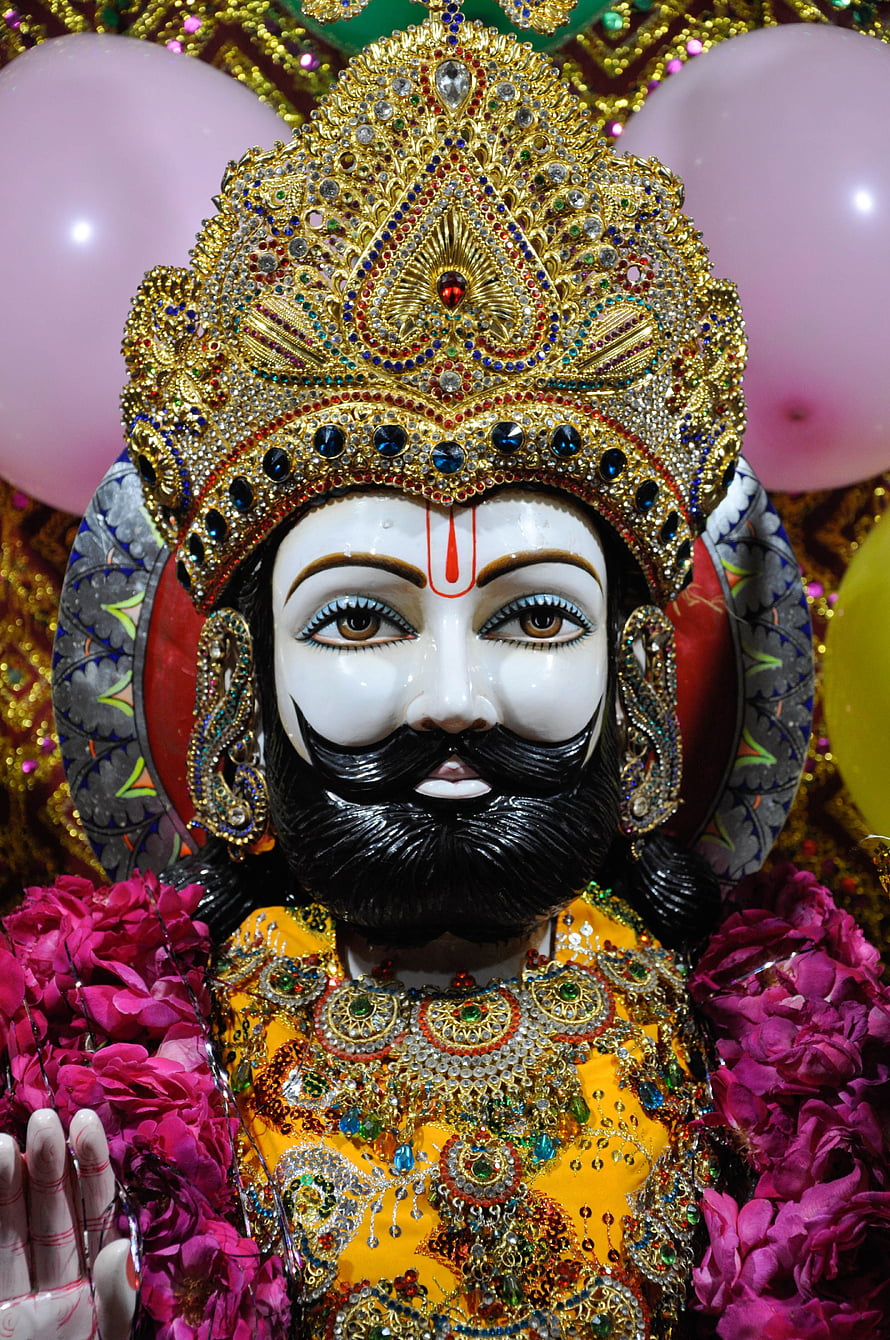 Ornate Hindu Deity Idol with Golden Crown and Floral Garlands HD phone wallpaper