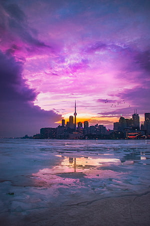 Toronto Skyline at Dusk with Vibrant Purple Clouds and Frozen Lake Shore HD phone wallpaper
