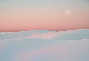 Pastel White Desert Dunes Under a Soft Pink Sky with a Faint Moon HD wallpaper