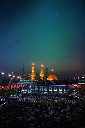 Imam Hussain Shrine in Karbala at Night with Pilgrims and Illuminated Minarets HD phone wallpaper