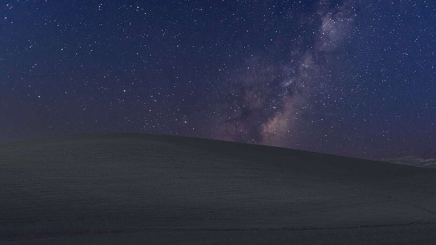 Milky Way Galaxy Arching Over a Dark Rolling Hill Under a Starry Night Sky HD wallpaper