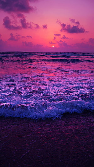 Vibrant Purple Ocean Sunset with Foaming Waves on a Dark Sandy Shore HD phone wallpaper