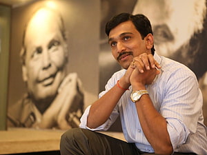 Pratik Gandhi in a candid portrait with a vintage black and white photograph in the background HD wallpaper