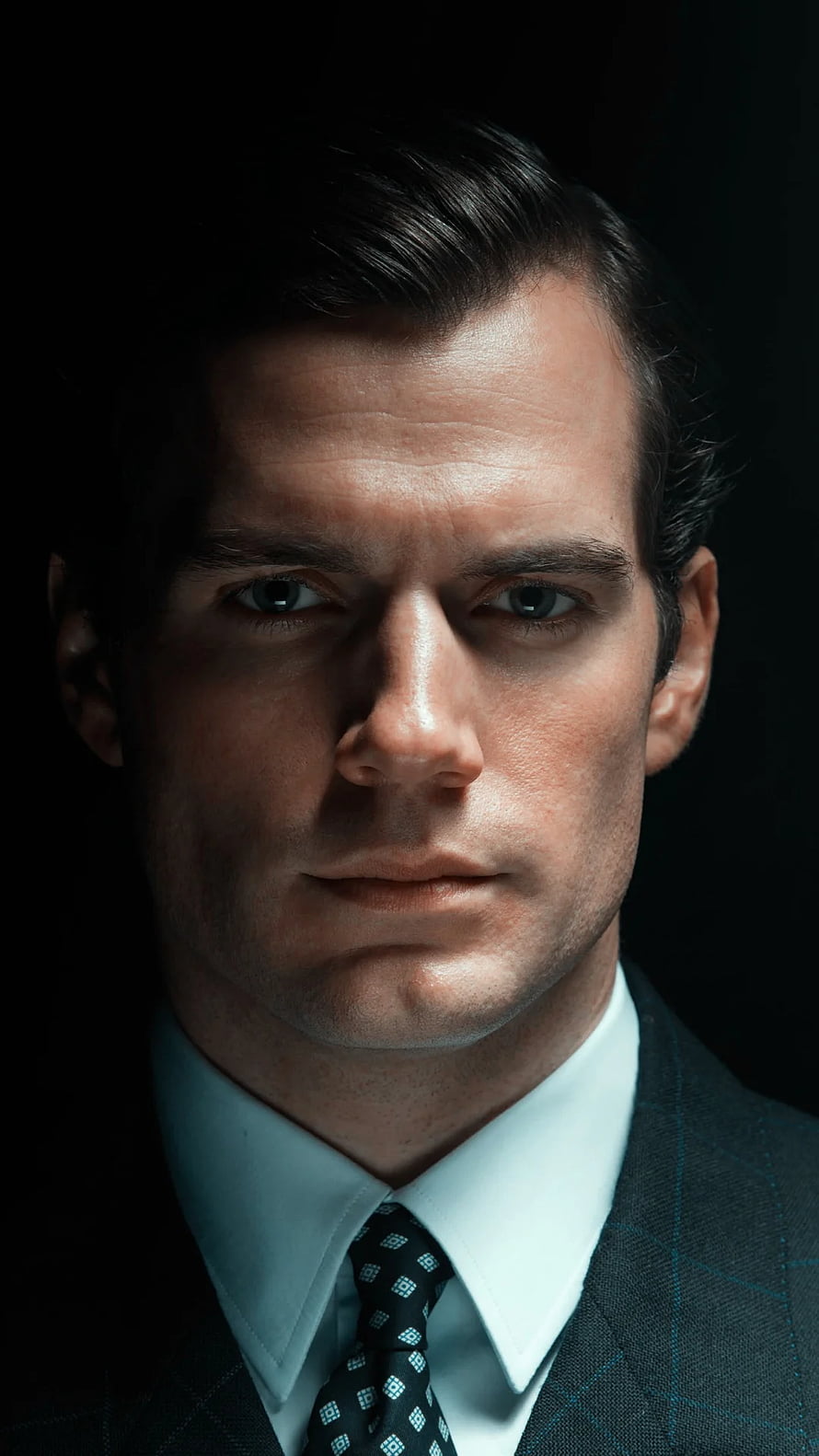 Henry Cavill in a dark suit and patterned tie with dramatic low-key studio lighting HD phone wallpaper