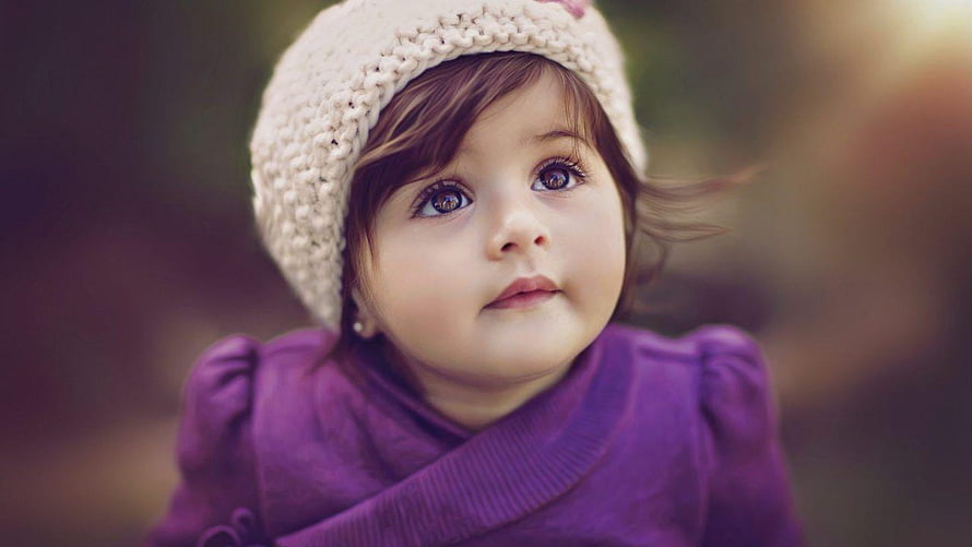Adorable Toddler Girl Wearing a Knit Beanie and Purple Coat in Soft Outdoor Light HD wallpaper