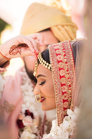 Bride in red lehenga and gold jewelry during Indian wedding ceremony HD phone wallpaper