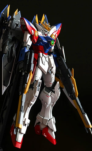 Gundam Model Kit with Red Blue White Armor and Winged Backpack on Black Background HD phone wallpaper