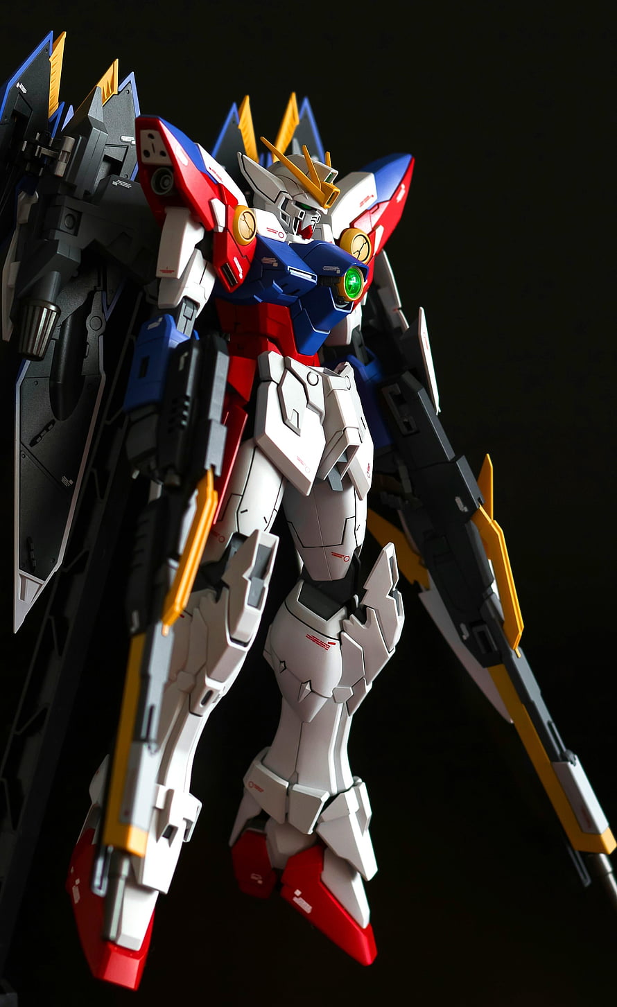 Gundam Model Kit with Red Blue White Armor and Winged Backpack on Black Background HD phone wallpaper
