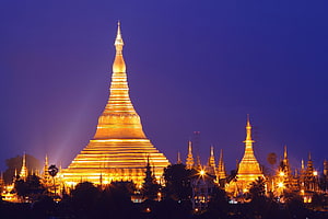 Shwedagon Pagoda glowing gold against a deep blue twilight sky in Myanmar HD wallpaper