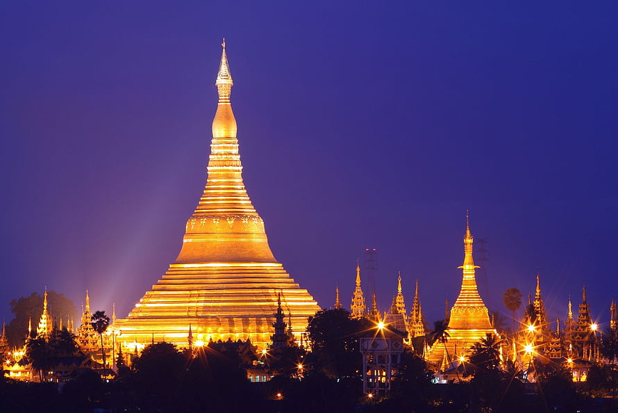 Shwedagon Pagoda glowing gold against a deep blue twilight sky in Myanmar HD wallpaper