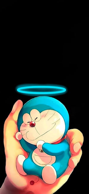 Doraemon sleeping peacefully in a hand with a glowing halo against a black background HD phone wallpaper