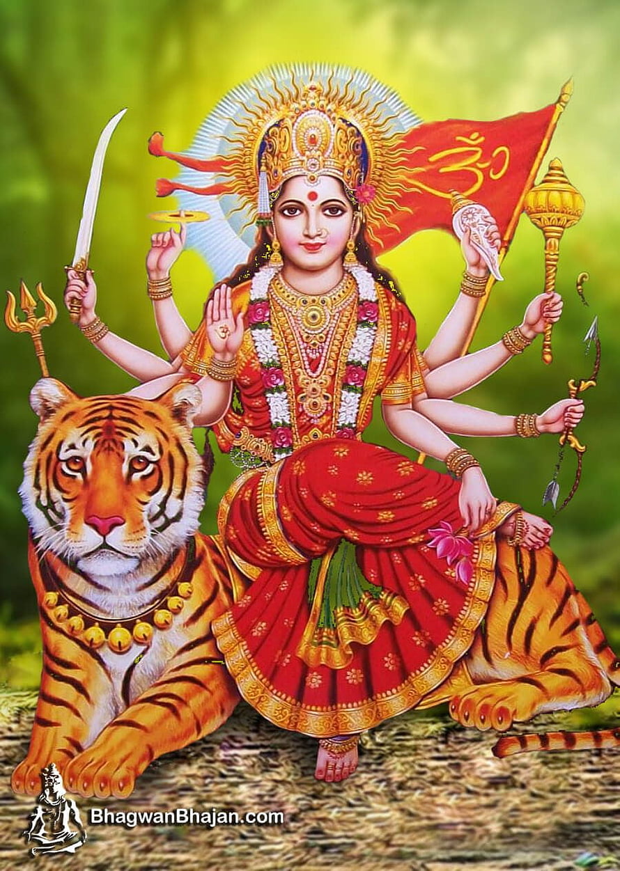 Maa Durga riding a tiger with multiple arms holding sacred weapons and a red flag HD phone wallpaper