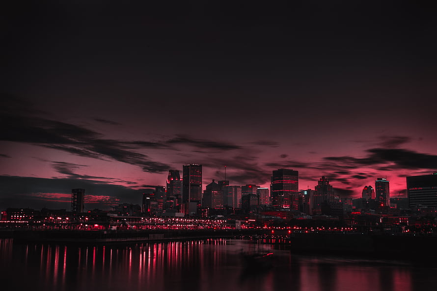 Dramatic Red Tinted City Skyline at Night with Water Reflections HD wallpaper