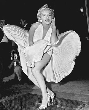 Marilyn Monroe in a flowing white gown striking a dramatic pose at a nighttime event HD phone wallpaper