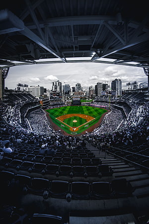 Wide-angle view of a packed baseball stadium with city skyline backdrop and retractable roof structure HD phone wallpaper