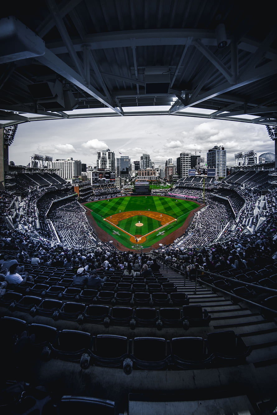 Wide-angle view of a packed baseball stadium with city skyline backdrop and retractable roof structure HD phone wallpaper