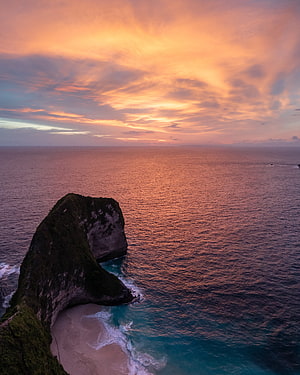 Aerial View of Dramatic Coastal Cliffs and Hidden Beach at Golden Sunset HD phone wallpaper