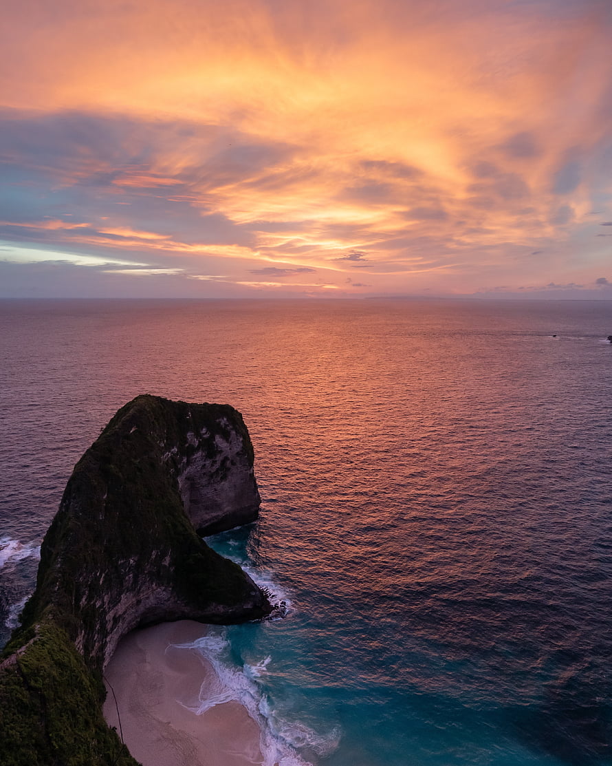 Aerial View of Dramatic Coastal Cliffs and Hidden Beach at Golden Sunset HD phone wallpaper