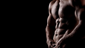 Dramatic Close-Up of Defined Male Abdominal Muscles in Dark Studio Lighting HD wallpaper