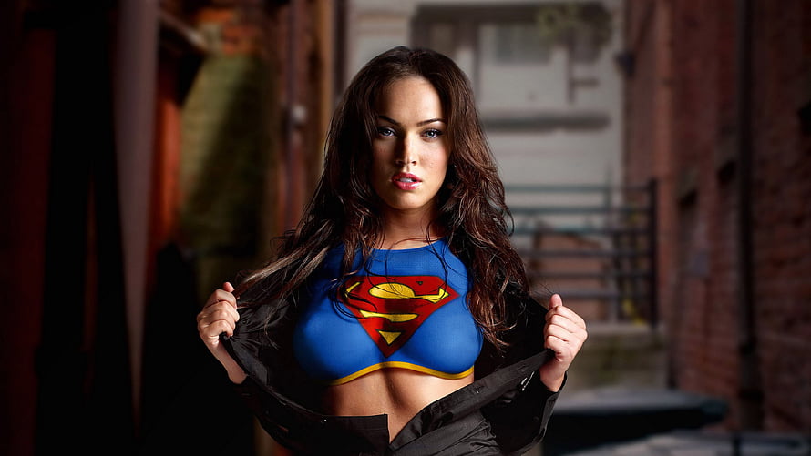 Megan Fox in a Supergirl costume standing in an urban alleyway HD wallpaper