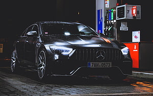 Black Mercedes-AMG GT 63 S Coupe Parked at Nighttime Gas Station HD wallpaper