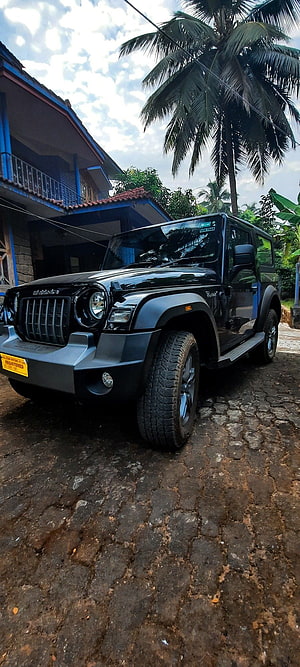 Black Mahindra Thar SUV Parked on Cobblestone Driveway with Tropical Palm Trees and House HD phone wallpaper