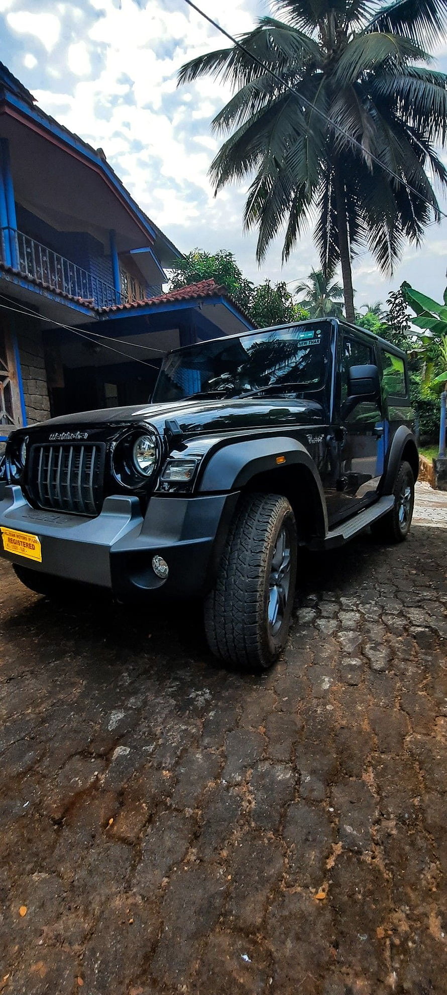 Black Mahindra Thar SUV Parked on Cobblestone Driveway with Tropical Palm Trees and House HD phone wallpaper
