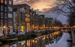 Amsterdam Canal at Dusk with Historic Gabled Houses and Warm City Light Reflections HD wallpaper