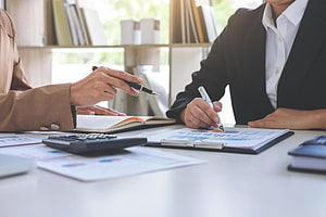 Business professionals reviewing financial charts and data during a collaborative office meeting HD wallpaper